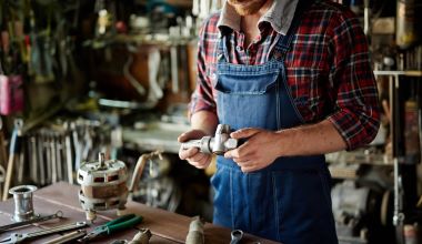 Plumber looking at spare part in his workshop